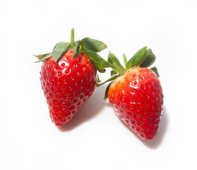 two strawberries lie next to each other in close-up, isolated on a white background