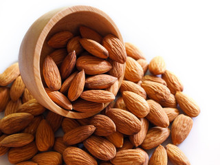 dried almonds in wooden bowl isolated on white background with copy space.