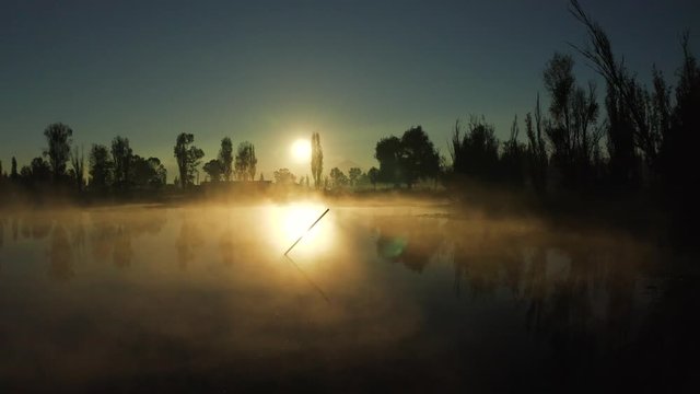 Aerial dolly in shot in Xochimilco with sun backlight