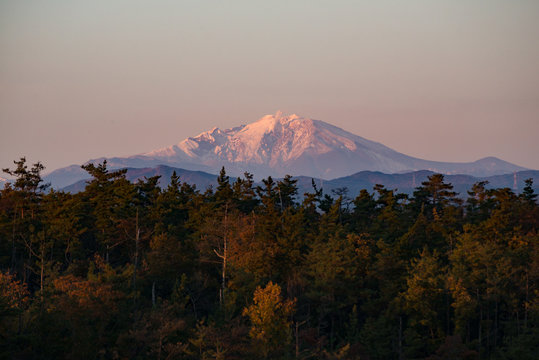 The scenery of the Ontake Mount in sunset time with a colorful foliage pine tree in Japan.
