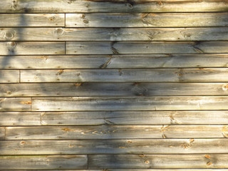 texture of horizontal wooden planks, burnt and rotten, with shadow from trees