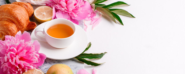 Peonies, cup of herbal tea, fruit on white background. Spring flowers. Spring breakfast background. Greeting card for Valentine's Woman's Mother's Day, wedding, banner