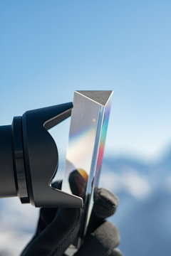 Close up view of professional photographer taking picture with triangle glass prism. Photography equipment concept. Camera lens protection blend close up.
