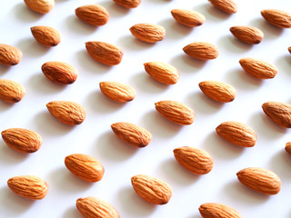 Pattern seamless background with dried almonds isolated on white background with copy space.