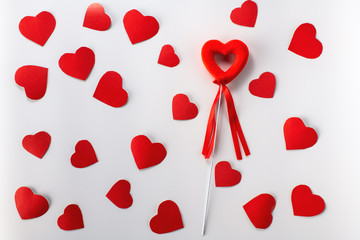 Valentine's day. Red decorative heart on a white background and a lot of small cardboard hearts. The view from the top..
