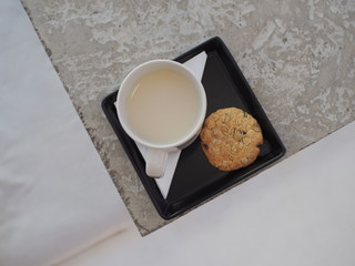A mug of soy milk with healthy grain cookie.