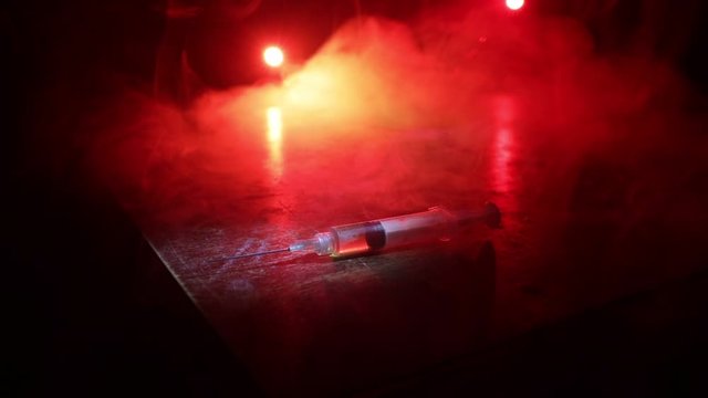 Narcotic drug problem concept. Drug syringe and narcotic attributes on wooden table. Purchase, possession and sale of drugs is punishable by law. Creative artwork decoration