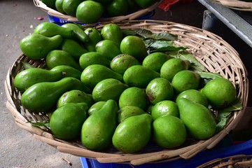 Pile of avocados in a rustic basket for sale.  Healthy food bacground. Picture from a morning market.