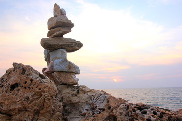Stone sort at the sea or beach on the sunset, zen stone.Stones pyramid on rock  Ocean in the background.