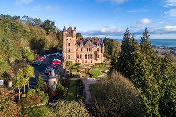 Belfast castle. Built in 19th  Tourist attraction on the slopes of Cave Hill Country Park in Belfast, Northern Ireland. Aerial view. Belfast Lough in the background