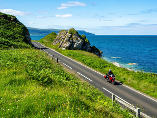 De oostkust van Noord-Ierland en Antrim Coast Road A2, ook bekend als Causeway Coastal Route met een motorfiets. Een van de mooiste kustwegen van Europa
