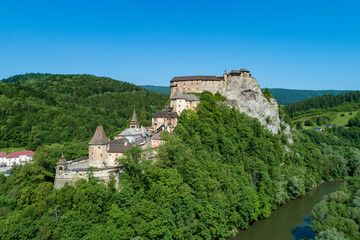 Fototapeta na wymiar Orava castle - Oravsky Hrad in Oravsky Podzamok in Slovakia. Medieval stronghold on extremely high and steep cliff at Orava river. Aerial view