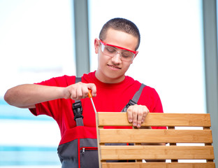 Young furniture carpenter in industrial concept