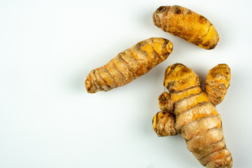 Raw fresh tumeric on white background with copyspace.
