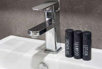 Shower gel, lotion and shampoo on bathroom sink. Water tap head design 2.