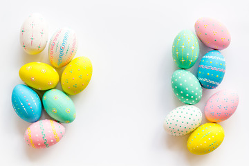 Colorful Easter eggs frame on white background top-down copy space