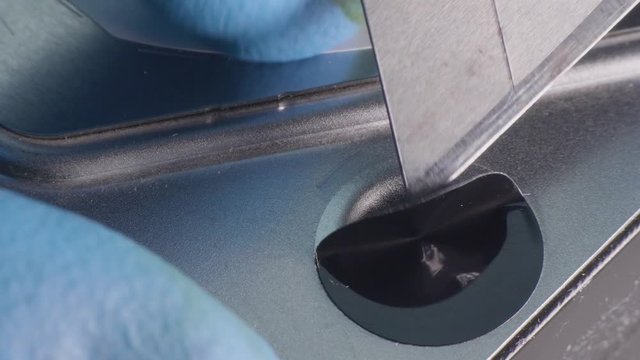 Hands in blue gloves remove sticker seal from hard disk case. Close-up top view 