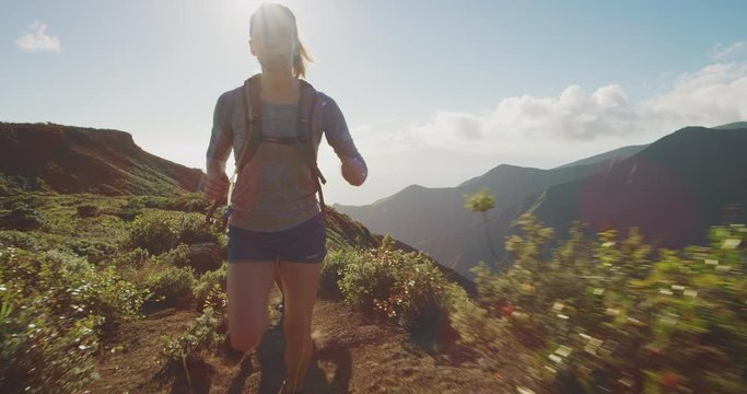 Young active trail runners exploring the top of a mountain in the afternoon, ultra marathon runners adventuring outdoors running fast, outdoorsy couple running together