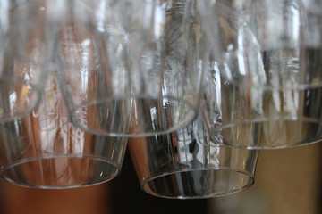Glass for put wine hanging upside down on a rail at the counter bar.
