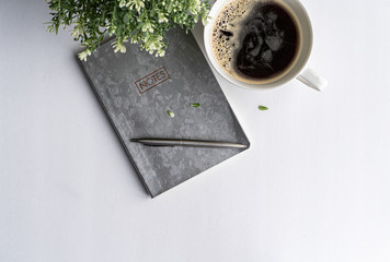 Work space in modern style with a notebook and coffee cup on white background.