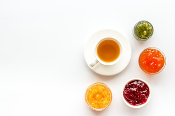 Fruit jam near tea on white kitchen desk frame copy space