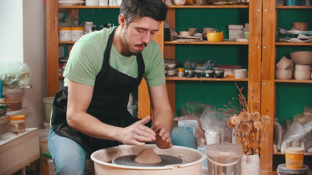 Pottery - the man is begining to mold clay on the potter's wheel
