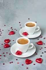 Red confetti,  sweets and two coffe cups on  gray background. Valentines day concept