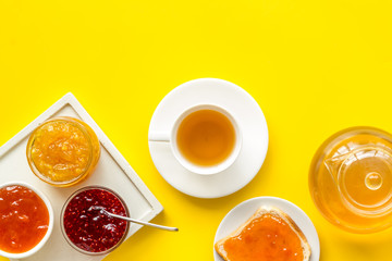 Tea party with jam. Toast, teapot, cup on yellow background copy space