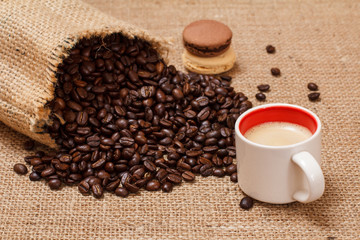 Fototapeta premium Cup of coffee and roasted coffee beans in a canvas sack.