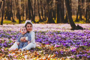 Sister and brother sitting in the middle of crocus valley