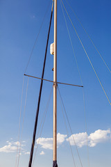 Mast of sailing yacht against blue sky background