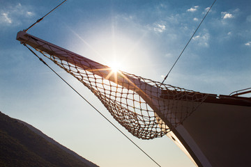 A bowsprit of a moored yacht in the evening