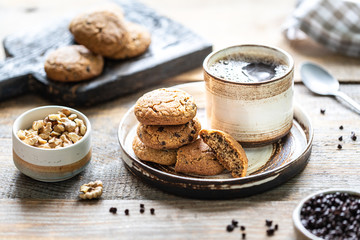 Homemade cookies with nuts and hot coffee in a ceramic cup