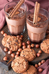 Aromatic cocoa drink with cinnamon and sweet cookies on  wooden rustic background