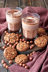 Aromatic cocoa drink with cinnamon and sweet cookies on  wooden rustic background