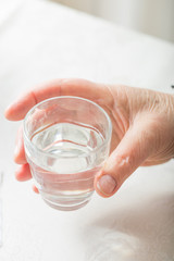 Female hand hold glass of water. Healthcare and medical for elder. Medicines for treatment old senior people.