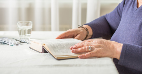 Elderly Caucasian Woman Reads A book. Pensioner Relaxation and brain education pleasure concept. Close Up.