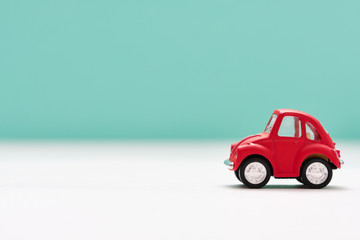 Side view of a red toy car on blue background