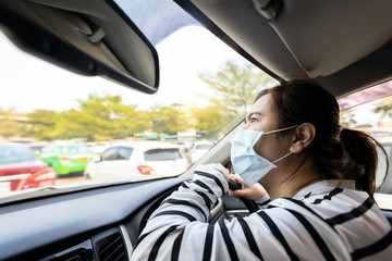 Stressed asian woman wearing medical face mask,worried about allergic to dust,air pollution,PM 2.5,smog,dust in the city,anxiety female people sitting in the car,pollution protection,dust allergy