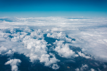 Sky with clouds from airplane window during flight.