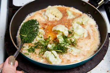 Cooking. Frying Broccoli in a pan with a liquid egg