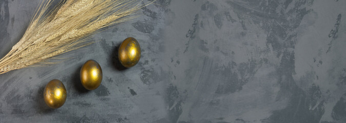 Easter Decoration With three Golden Eggs on Dark Shale Background. Copy space.