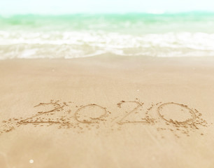 Happy new year , lettering numbers 2020 year on the sand