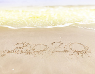 Happy new year , lettering numbers 2020 year on the sand