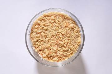 Crushed hazelnut pieces in a glass bowl