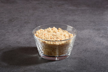 Crushed hazelnut pieces in a glass bowl