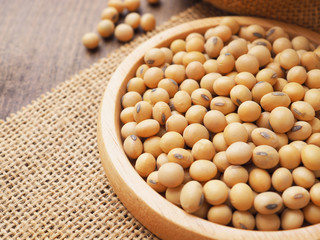 Soybeans in wooden plate on sackcloth background, Protein plant health food..