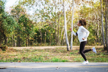A young asian woman jogging in city park in the morning
