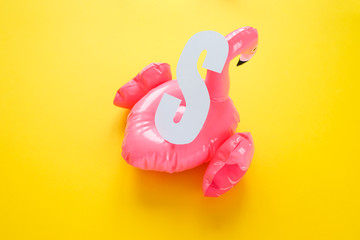 Inflatable pink flamingos on an yellow background.