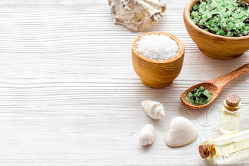 Spa set with mineral salt and oil on white wooden background copy space